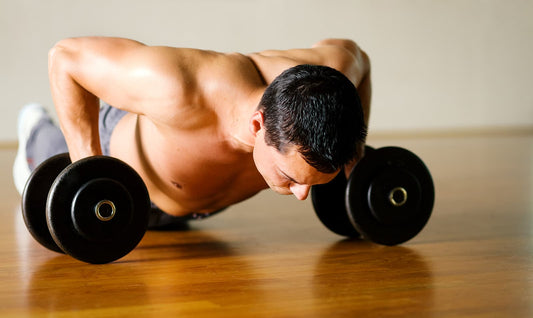 adjustable dumbbells - man doing push-ups on dummbells
