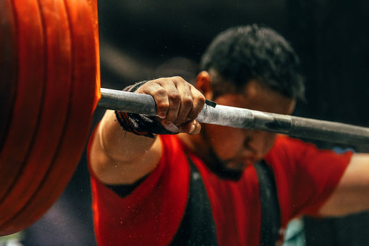 olympic rubber bumper plates - male powerlifter preparing for squats with a barbell during competition of powerlifting