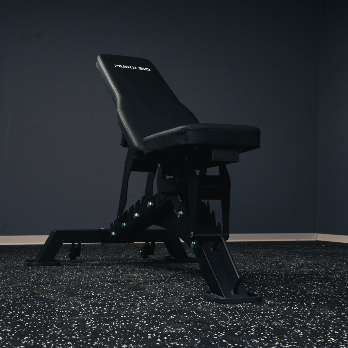 Low front view of the MUSCLEIQ tri-legged commercial weight bench with inclined backrest and single front support