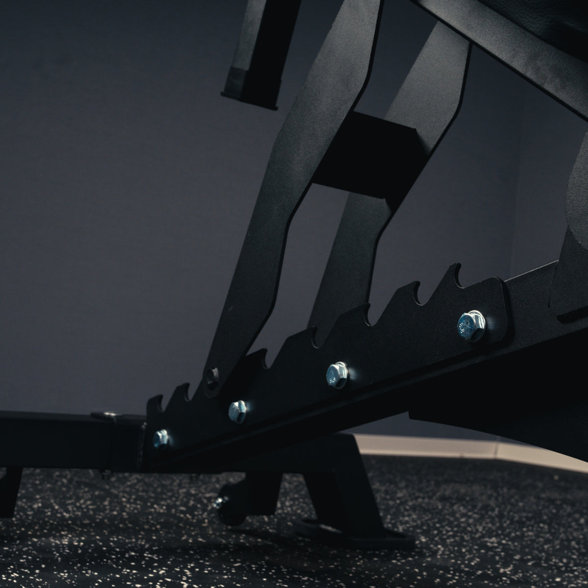 Close-up of the notched backrest adjustment rail and steel support on the MUSCLEIQ tri-legged commercial weight bench